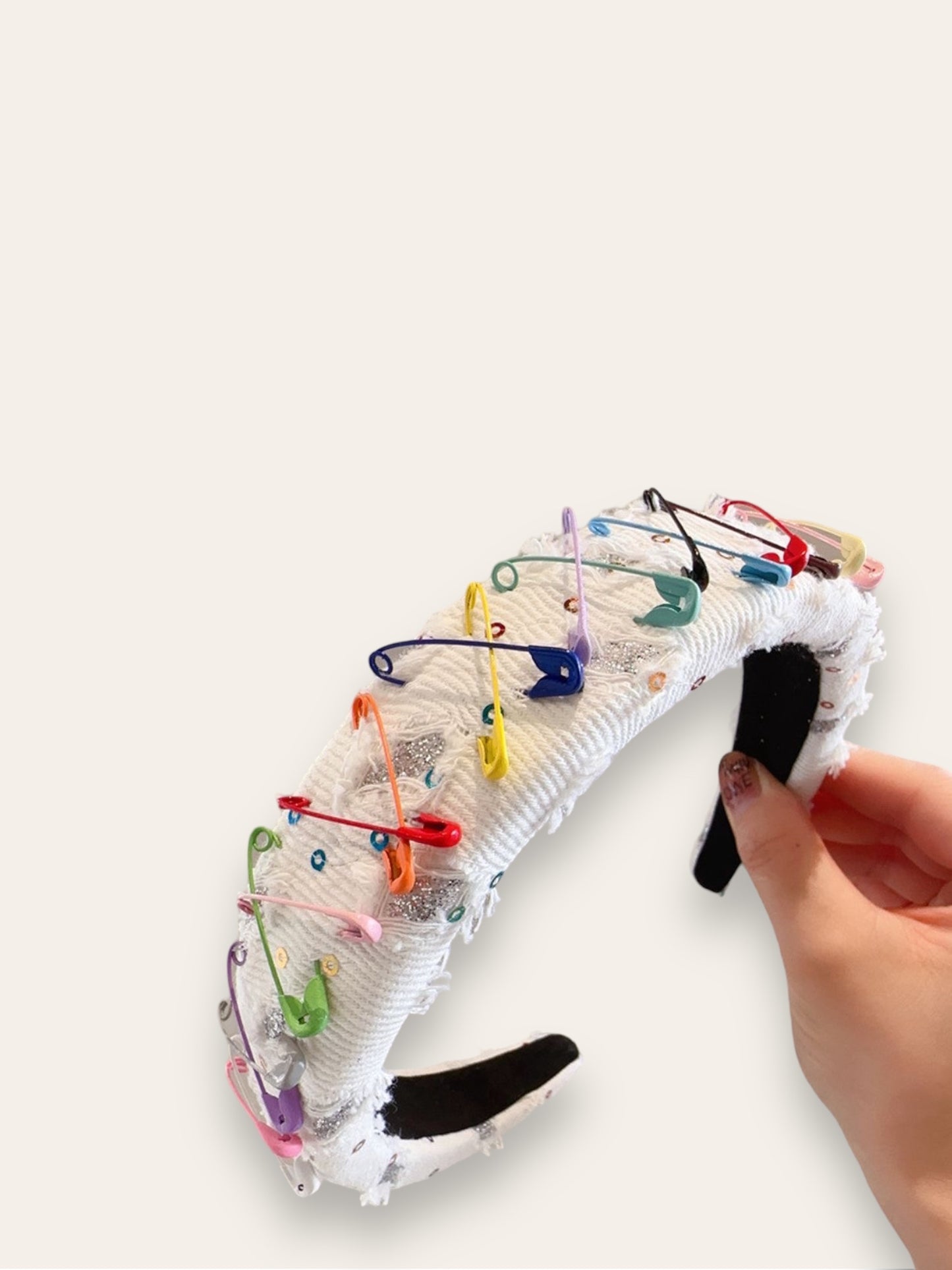 Diadema blanca con broches de colores.